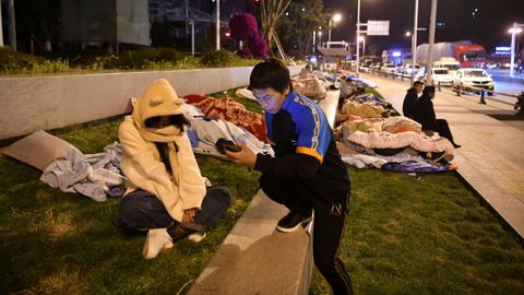 Residentes de la provincia china de Yunnan siguen la evoluci�n de los terremotos instalados en las calles 