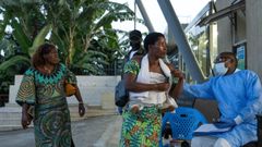 Un trabajador del Congo mide la temperatura a un grupo de mujeres.