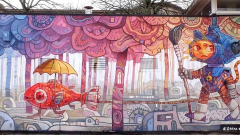 &laquo;Cami&ntilde;antes&raquo;. En la escola A Gali&ntilde;a Azul de la Praza da Constituci&oacute;n, 2.&nbsp;En este mural Miguel Peralta nos trae su mundo on&iacute;rico y m&aacute;s fant&aacute;stico, para contarnos una divertida y bonita historia: un chico sol llegado de un lugar seco y caluroso, se adentra con su escafandra y su pincel en un mundo submarino, h&uacute;medo y profundo.