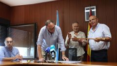 Jesús Reboredo recibe el bastón de mando tras ganar la votación de la moción de censura contra Roberto Castro (derecha), del Movemento Veciñal de Touro, que perdió el apoyo de un edil que hizo posible el cambio de gobierno