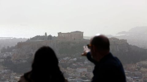 Dos personas contemplan la Acr�polis de Atenas desde un mirador.