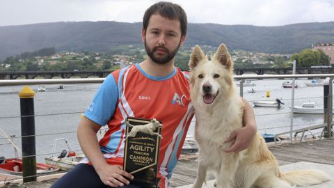 Jonathan, retratado en Pontedeume con su trofeo y su perrita Dana