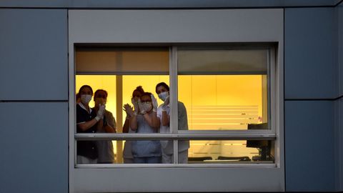 Aplauso interhospitalario. Sanitarios del Hospital San Rafael de A Coruña aplauden a sus compañeros del Chuac -ambos hospitales están uno frente al otro- durante la cita diaria de las 20 horas que se instauró en todo el país. Esta foto se tomó el 24 de marzo