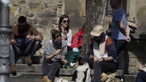 Varias personas toman el sol en una plaza de Cimavilla