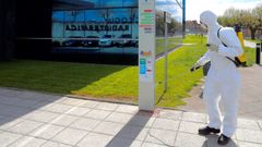 Un operario desinfecta hoy jueves en los aleda�os del Hospital Universitario Central de Asturias (HUCA)