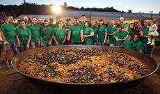 El amplio equipo organizador posa junto a la monumental paella servida ayer en Cortegada. 