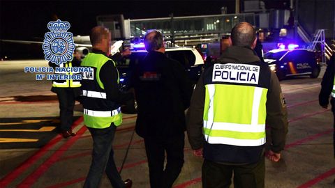 dos agentes de polic�a mientras escoltan a Carlos Garc�a Juli� (c), uno de los autores de la matanza de Atocha de 1977, tras ser extraditado por Brasil, en febrero de este a�o