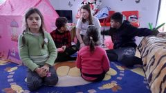 Sasha, entre sus dos hermanos, frente a Maria y Sofia, hijas de Adrian, que hospeda refugiados en su casa