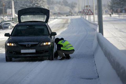 Un hombre coloca cadenas en su coche. ARCHIVO