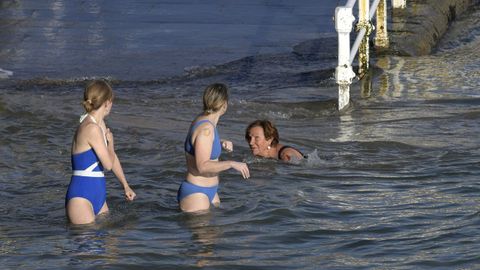 Un grupo de personas se baa este sbado en la playa de San Lorenzo, Gijn.