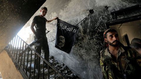 Un miembro de las Fuerzas Democr�ticas Sirias llama a sus compa�eros durante el combate con el Estado Isl�mico en Raqqa, Siria
