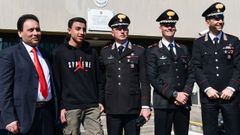 Ramy, de 13 a�os, posa con su padre y con agentes que intervinieron durante el suceso, ocurrido a las afueras de Mil�n