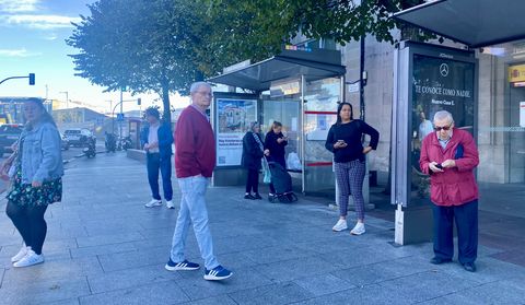 Personas esperando hoy en una parada de autobs de Vigo