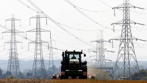 granjero trabaja en un campo rodeado del tendido de electricidad en Ratcliffe-on-Soar, en el centro de Inglaterra.