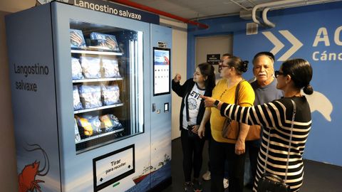 En las m�quinas se venden langostinos f�ciles de pelar en varios formatos. En la imagen, una familia observa la oferta en el aparcamiento del N�utico.