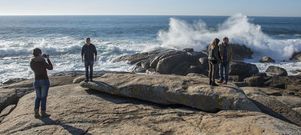 Visitantes ayer por la tarde sobre la Pedra de Abalar de Mux�a mientras el mar rompe al fondo contra las rocas. 
