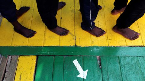 Un grupo de inmigrantes esperan a desembarcar al llegar al puerto de Crotone, tras ser rescatados en el Mediterr�neo