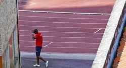Un atleta camina junto al tart�n durante un entrenamiento. 