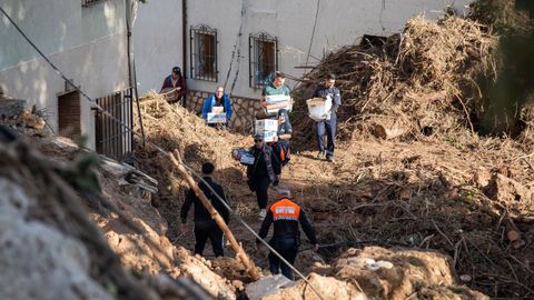 Varias personas trabajan en el desescombro de una zona afectada por la dana en Letur