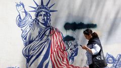 Una mujer pasea por Teher�n (Ir�n) frente a un mural cercano a la embajada de Estados Unidos.