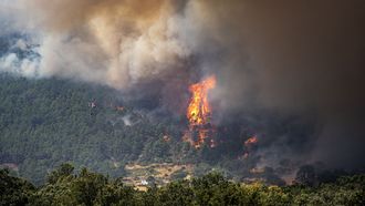 Un helic�ptero trabaja en las labores de extinci�n del fuego en el municipio de El Tiemblo, en �vila