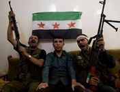 Combatientes del grupo Liwa al Tawhid posan con un sospechoso prorr�gimen en Alepo.