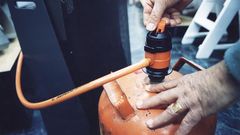 Una bombona, con el regulador y la goma, en una foto de archivo