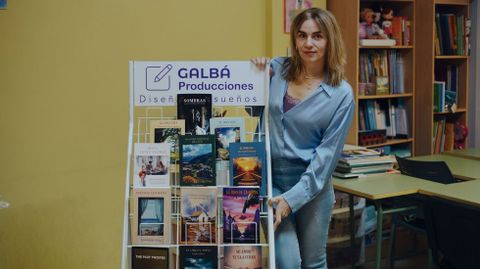 Mercedes Barros, con el expositor de los libros publicados por Galbá Producciones.