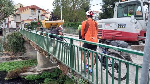 Peregrinos y maquinaria de obras en el actual puente, en una foto de archivo 