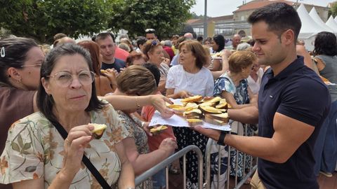 Un momento del reparto de raciones de rosca en la plaza del Concello
