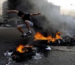 Un opositor antisirio salta con su monopat�n sobre una barricada de fuego en Beirut.