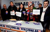 Representantes de los tres colectivos muestran los carteles que ya se distribuyen desde ayer.