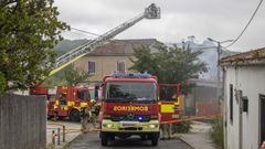 Operativo de los bomberos de Santiago para sofocar el incendio en la vivienda ocupada en el Monte de Conxo