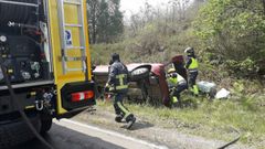 Bomberos de La Morgal con el coche accidentado en Siero