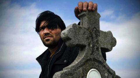 Vigilados en el cementerio. Un hombre sirio apoyado sobre una cruz cristiana de una cementerio en la frontera de Serbia y Croacia, lugar donde fueron obligados a pasar varios d�as y noches con temperaturas m�nimas vigilados por la polic�a que les rodeaba. 