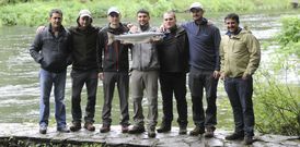 Rub�n Golpe Mondrag�n sostiene el salm�n acompa�ado de sus amigos. 