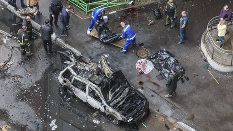Operarios recogen el cuerpo del teniente general ruso Yaroslav Moskalik, al lado del coche bomba.
