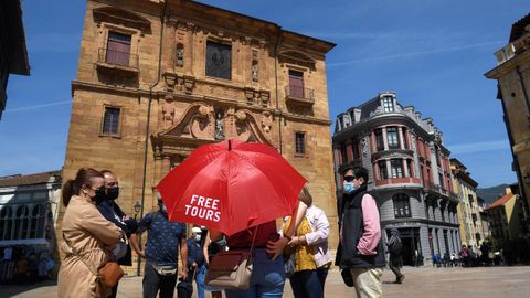 Un grupo de turistas atienden las explicaciones de un guía en la plaza del Ayuntamiento de Oviedo