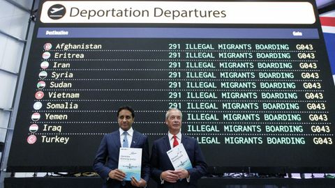 Nigel Farage y Zia Yusuf, jefe del Departamento de Eficiencia Gubernamental de Reform UK, sostienen folletos mientras posan frente a una pantalla que muestra Salidas de Deportación.