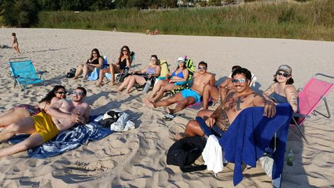 Gente siguiendo el eclipse solar desde la playa de Area, en Viveiro