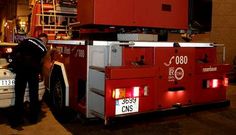 Un polic�a gu�a la maniobra de un cami�n de bomberos junto a un turismo mal estacionado.