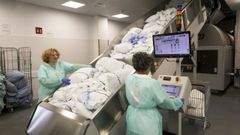 La ropa sucia se introduce por una cinta transportadora para iniciar su proceso de lavado.