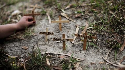 Un activista establece cruces con el nombre de varias mujeres asesinadas en El Salvador.