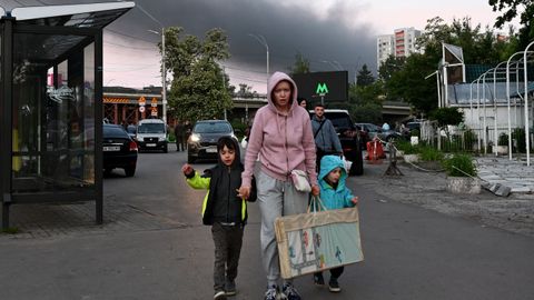 Una mujer regresa de un refugio junto a sus hijos, tras los ataques con misiles y drones rusos en Kiev