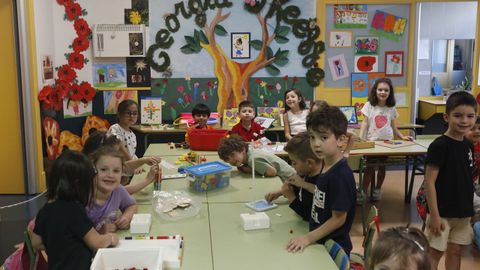 Pequeos del Irmns Villar, frente a sus dibujos expuestos en clase