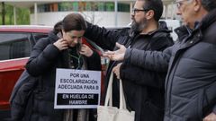 Carmen se cuelga un cartel antes de iniciar la protesta, este lunes en A Coru�a.