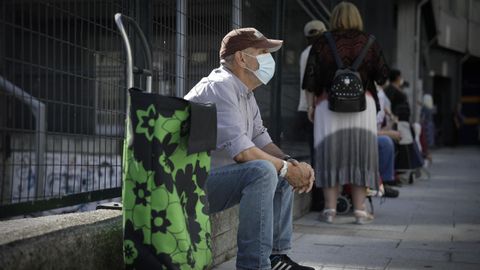 Personas haciendo cola para recibir alimentos ante la asociacin Renacer de A Corua