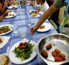 Una mujer sirviendo comidas en un colegio en foto de archivo.