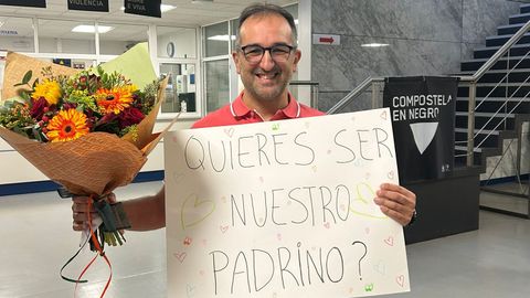 Carlos Resua posa con la pancarta y con el ramo de flores que le dieron sus alumnos de Óptica en la USC.