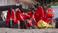 Varios migrantes descansan en la playa de Las Galletas, en el sur de Tenerife, a la que arribaron por sus propios medios, tras llegar a bordo del primer cayuco que ha alcanzado Canarias en el recin estrenado 2025 con 60 personas, dos de ellas fallecidas.